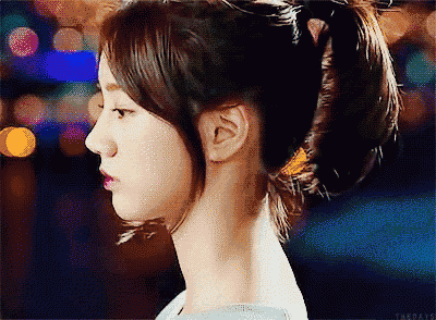 a close up of a woman 's face with a ponytail on her head