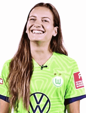 a woman wearing a green shirt with the letter w on it is smiling