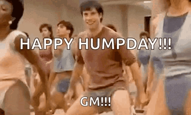 a group of people are dancing in a gym and a man is dancing in front of them .