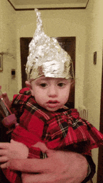 a little girl wearing a tin foil hat looks at the camera