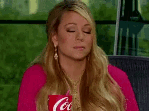 a woman in a pink shirt is holding a red coca cola cup .