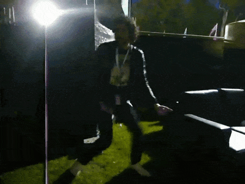 a man with a lanyard around his neck is standing in a dark room