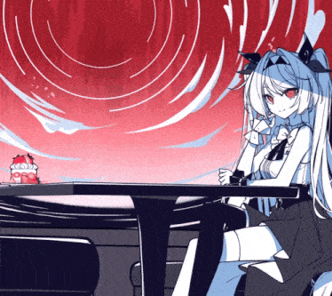 a girl sitting at a table with a cake on it