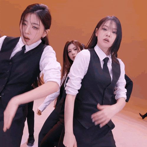 a group of women in suits and ties are dancing on a stage