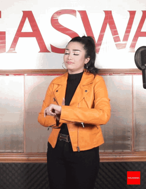 a woman in a yellow jacket stands in front of a gaswa sign
