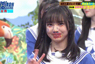 a girl with paint on her face is giving the peace sign .