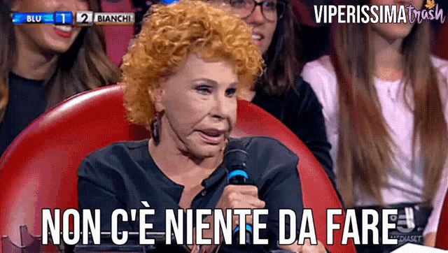 a woman holding a microphone with the words non c ' e niente da fare below her