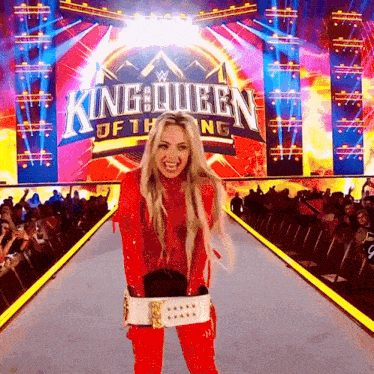 a woman is standing in front of a king queen sign