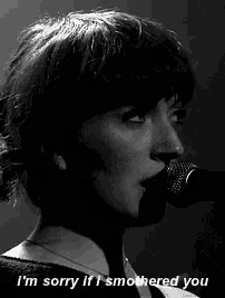 a woman singing into a microphone with the words " i 'm sorry if i smothered you "