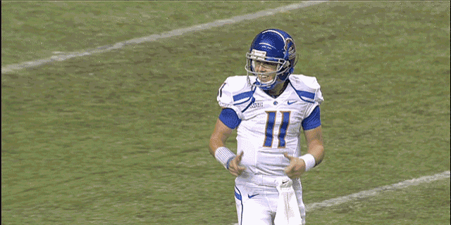 a football player with the number 11 on his helmet stands on the field