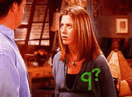 a man and a woman are looking at each other and the woman has a question mark on her sweater
