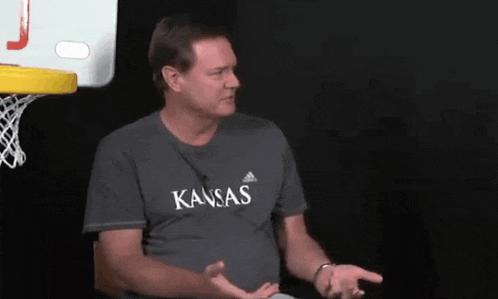 a man wearing a gray shirt that says kansas on it