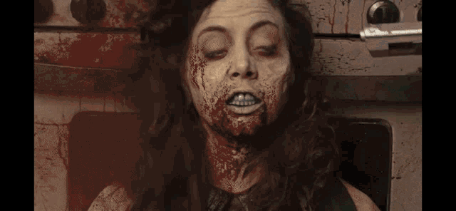 a woman with blood on her face laying on a stove