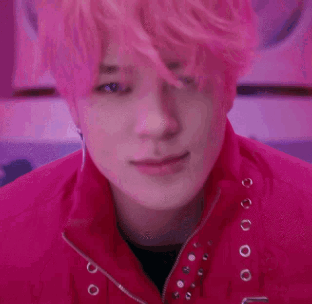 a close up of a person 's face with pink hair and a pink jacket .