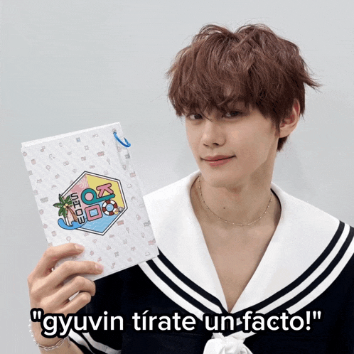 a young man in a sailor outfit is holding a book that says ' gyuvin tirate un-facto '