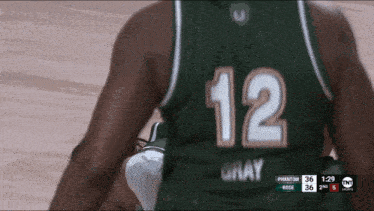 a basketball player wearing a green jersey with the number 12 on it
