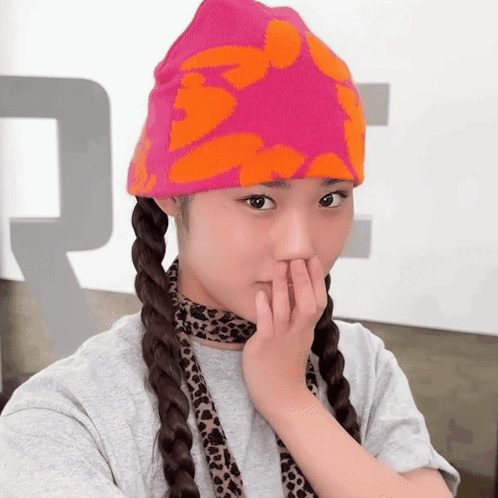 a girl wearing a pink and orange beanie and a leopard print scarf