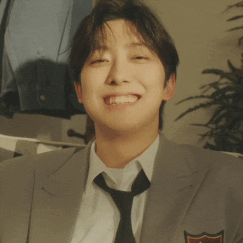a man wearing a suit and tie is smiling