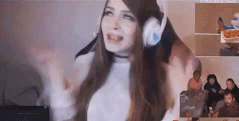 a woman wearing headphones is standing in front of a computer monitor .