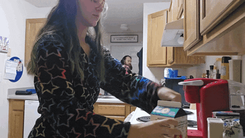 a woman in a kitchen with a sign that says " it 's a wonderful life " on it