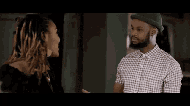 a man and a woman are standing next to each other and talking .