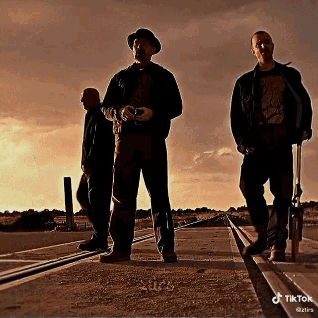 three men standing next to each other on train tracks with a tiktok watermark