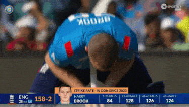 a man kneeling down in front of a screen that says ' strike rate ' on it