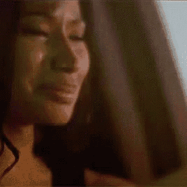 a woman is crying with her eyes closed and a tear running down her cheek .