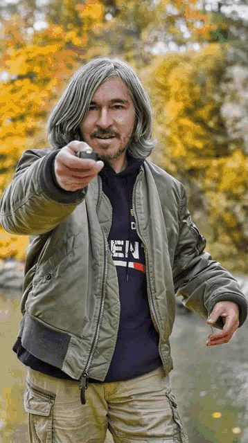 a man wearing a bomber jacket and a hoodie that says ' e.n. ' on it