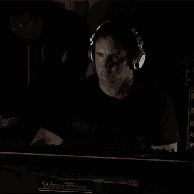 a man wearing headphones sits in front of a keyboard that says a 800