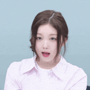 a woman wearing a pink and white striped shirt is making a surprised face