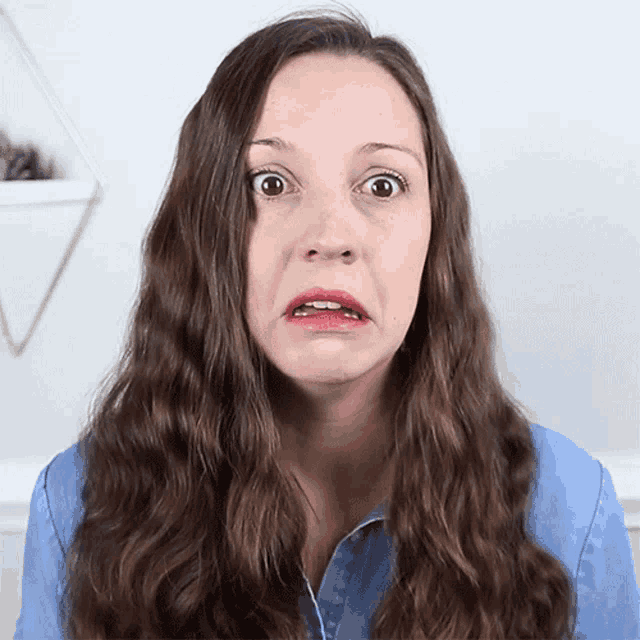 a woman with long brown hair making a surprised face