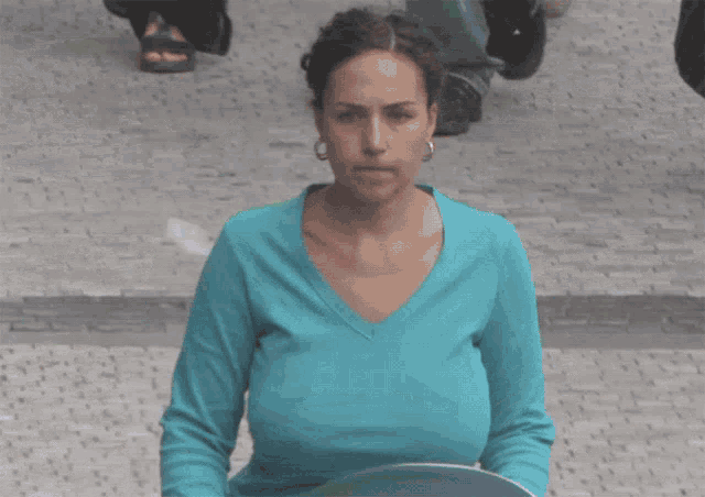 a woman in a blue shirt has a very large breast