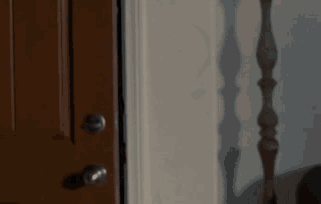 a man is standing in a doorway with his hand outstretched .