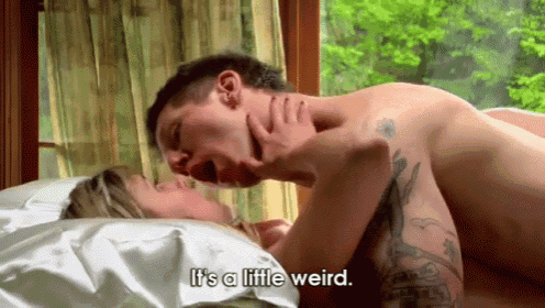 a man and a woman are having sex in bed and the man is saying it is a little weird .
