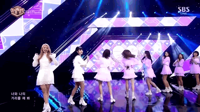 a group of girls are dancing on a stage with sbs live in the corner