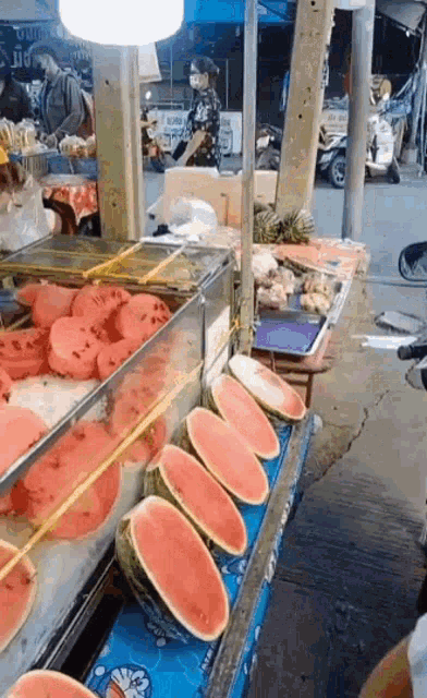 a display of watermelons with a doraemon sticker on them