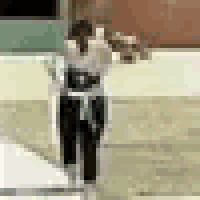a person in a white shirt and black pants is standing on a concrete surface .