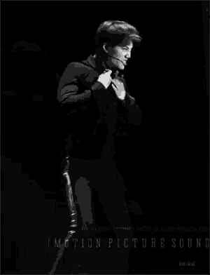 a man without a shirt is dancing in a black and white photo .