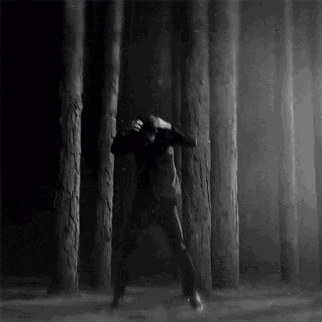 a black and white photo of a man in a forest