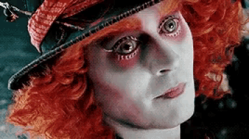 a close up of a person 's face wearing a hat and red hair .