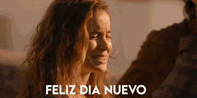 a woman is smiling in front of a feliz dia nuevo sign
