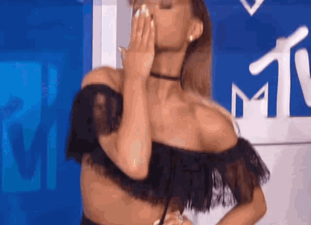 ariana grande is wearing a black off the shoulder top and a choker .