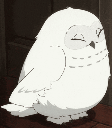 a white owl with yellow eyes is sitting on the floor
