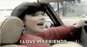 a woman is driving a car with the words `` i love my friends '' written on the screen .