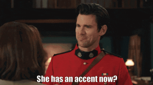 a man in a red uniform is talking to a woman who says she has an accent now