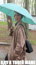 a man in a trench coat is holding a blue umbrella in the rain