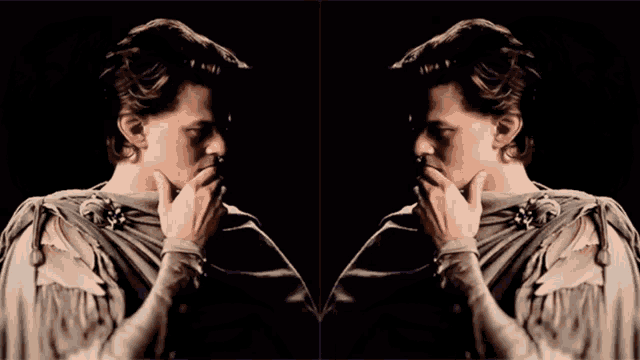 a man 's face is shown in a mirror with his hands on his chin