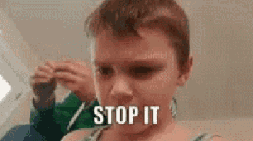 a young boy is making a funny face and the words `` stop it '' are on his face .