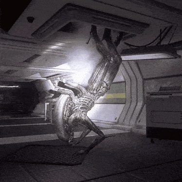 a statue of an alien hanging upside down in a dark room